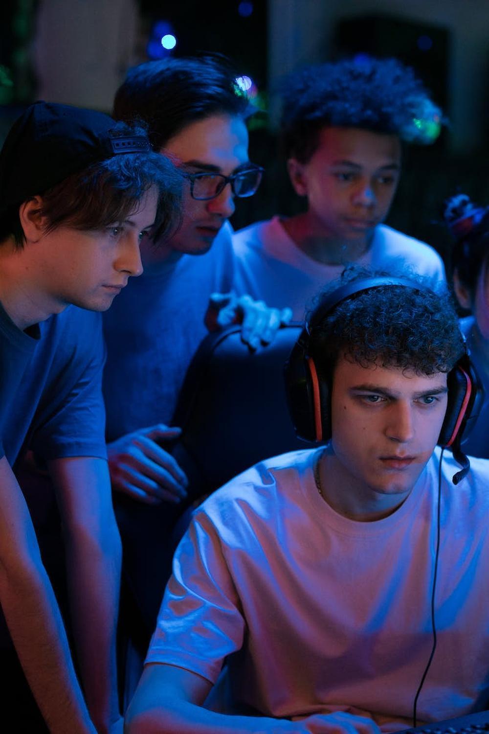 group_of_teenagers_watching_a_man_play_game_on_com