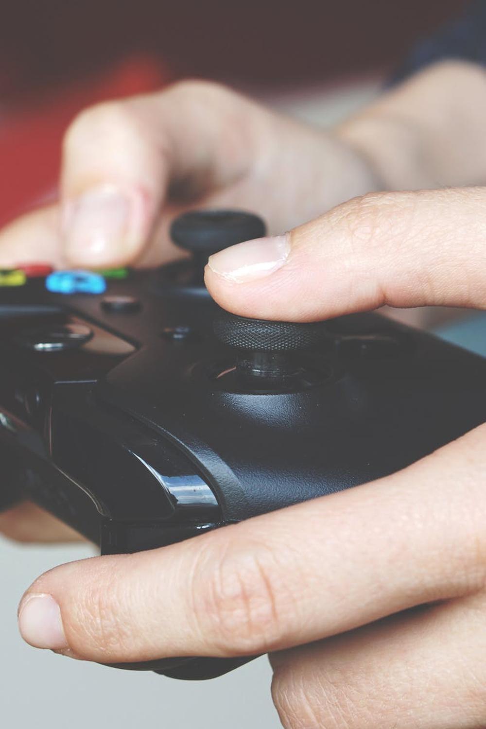  man_holding_black_game_controller