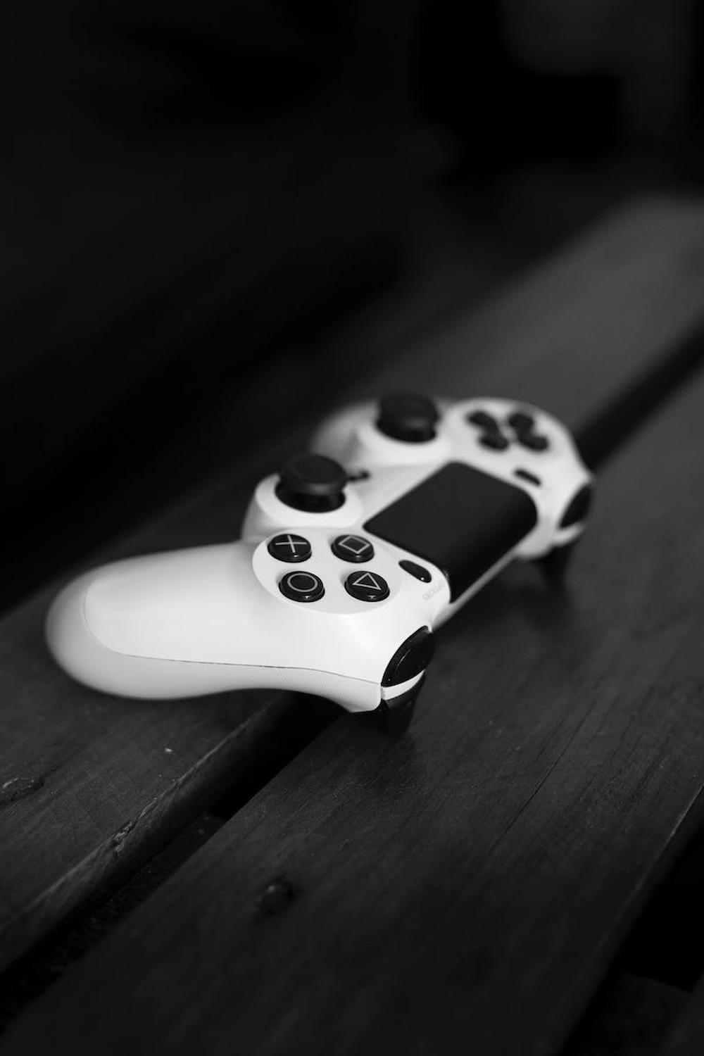 white_sony_dualshock_4_controller_on_black_wood_su